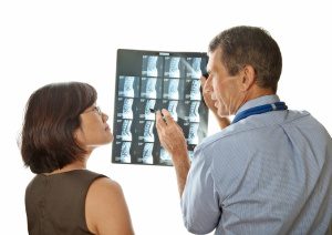 Male doctor and female patient viewing and discussing MRI (Xray) Spinal Scans